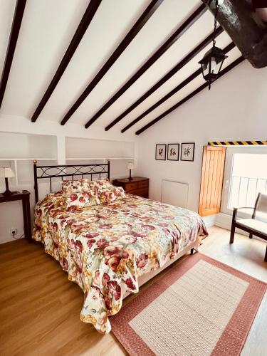 a bedroom with a bed with a floral bedspread at Quinta Do Sol Poente in Feteiras