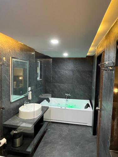 a bathroom with a bath tub and a sink at Gugal Bliss in Mahabaleshwar