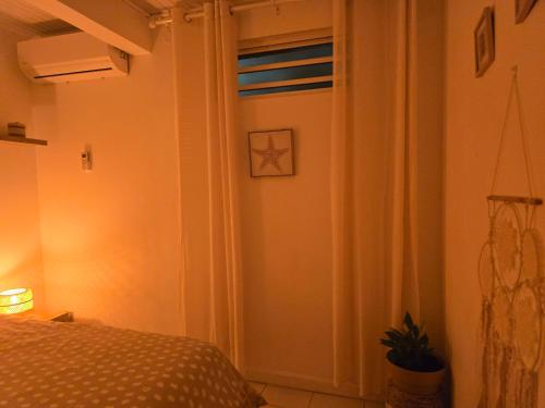 een slaapkamer met een bed en een deur met een raam bij ptit coin hibiscus in Pointe-Noire