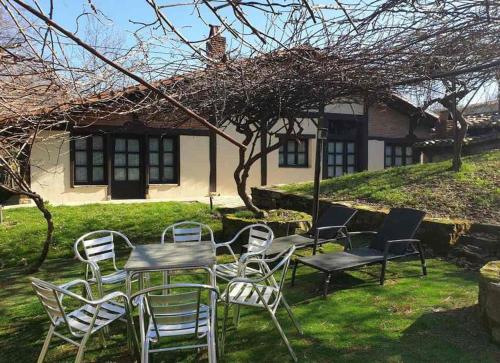 een tafel en stoelen voor een huis bij Albergue Rural Montebaserria in Ziortza-Bolibar