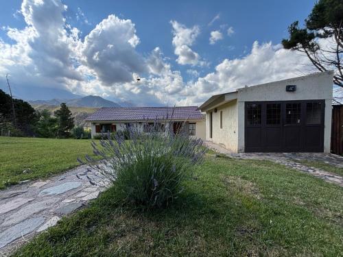 a house with a garage in a field at El Mirador in Potrerillos