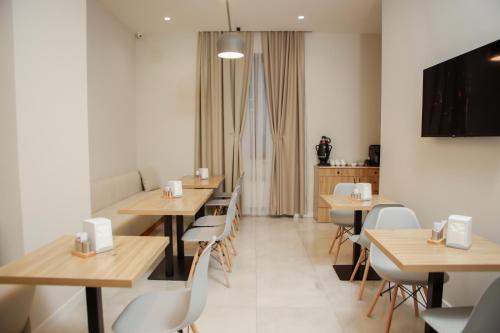 een restaurant met tafels en stoelen en een tv bij Barca Hotel in Jerevan
