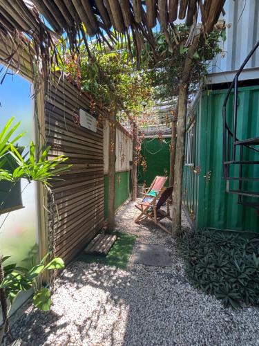 een tuin met een pergola en een bank bij Container Hospedaria Paraty in Paraty
