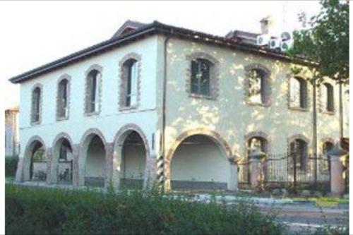 un grande edificio bianco con una recinzione di fronte di casavacanzasilvia a Rubiera