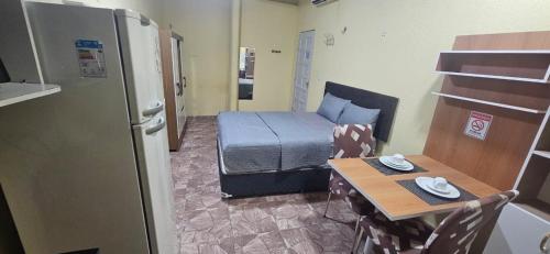 ein kleines Zimmer mit einem Bett und einem kleinen Tisch in der Unterkunft Cantinho bom! in Manaus
