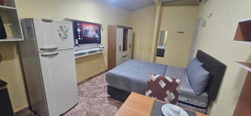 Kleines Zimmer mit einem Bett und einem Kühlschrank. in der Unterkunft Cantinho bom! in Manaus