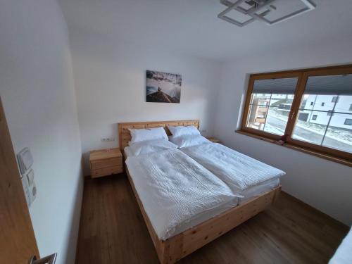 een slaapkamer met een bed in een kamer met een raam bij Bergpanorama Mühlhans in Gallzein