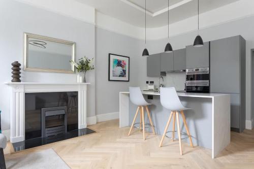 eine weiße Küche mit Kamin und weißen Stühlen in der Unterkunft Metro Luxe Suites in Porto Cervo