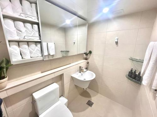 une salle de bains avec toilettes, lavabo et miroir dans l'établissement Kintex Golden Stay, 