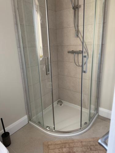 een douche met een glazen deur in een badkamer bij Guests house in Sligo