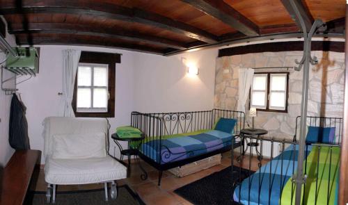 een kamer met een bed, een tafel en een stoel bij Albergue Rural Montebaserria in Ziortza-Bolibar