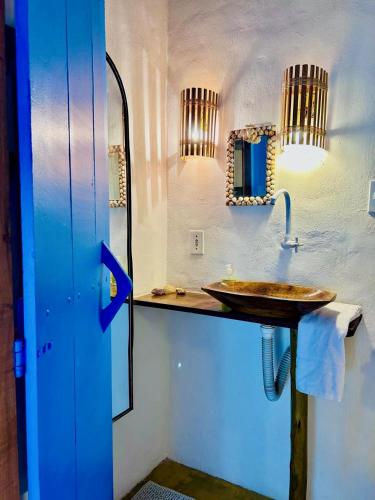 a bathroom with a sink and a mirror at Vila Iemanjá in Cumuruxatiba