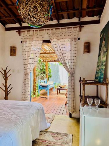 a bedroom with a bed and a stone fireplace at Vila Iemanjá in Cumuruxatiba