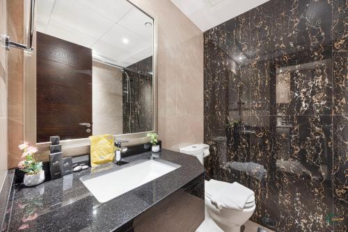 a bathroom with a sink and a toilet and a mirror at Spacious & cozy Studio in Downtown! in Sabkhah