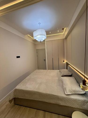 een slaapkamer met een groot bed en een kroonluchter bij doma24uz in Yakkasaray