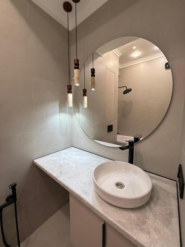 een badkamer met een wastafel en een spiegel bij doma24uz in Yakkasaray