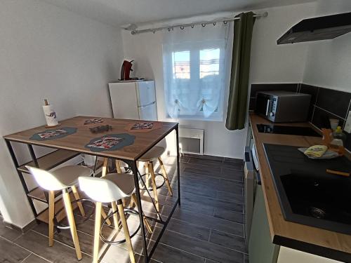 een kleine keuken met een tafel en een aanrechtblad bij Maison Les Hemmes d'Oye in Oye-Plage