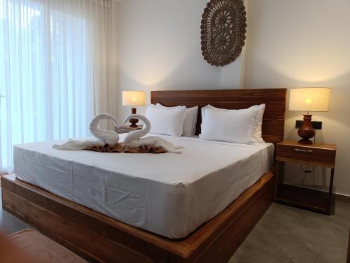 een slaapkamer met een bed met twee zwanen erop bij LUSSO Mirissa in Mirissa