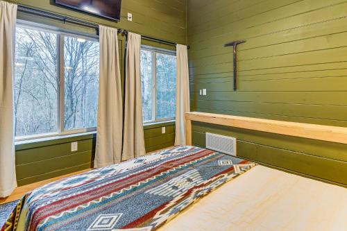 een slaapkamer met groene muren en een bed en ramen bij Secluded Red River Gorge Cabin with Rooftop Deck! in High Falls