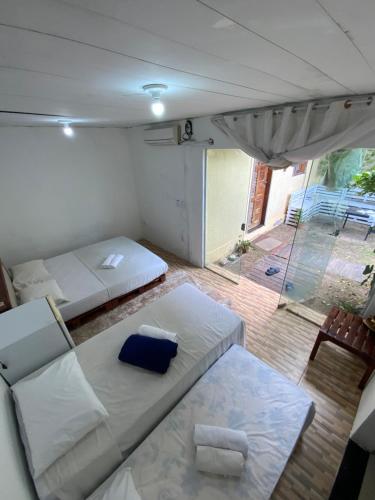 een woonkamer met 2 bedden en een balkon bij Lindo, simples, aconchegante e pé na areia in Fortaleza