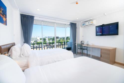 ein Hotelzimmer mit zwei Betten und Balkon in der Unterkunft IU Hotel Donmueang Airport in Ban Don Muang