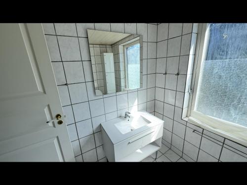 un bagno bianco con lavandino e specchio di Plads til børnefamilien i hjertet af Esbjerg a Esbjerg