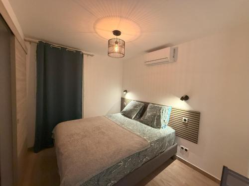 een slaapkamer met een bed met een groen gordijn bij Le Plumeria in Saint-Pierre
