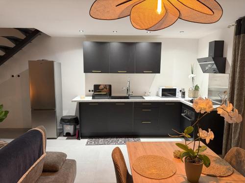 een keuken met zwarte kasten en een houten tafel bij Le Plumeria in Saint-Pierre