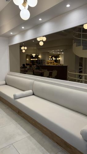 una panchina bianca in una stanza con specchio di Hotel Dion a Mar del Plata