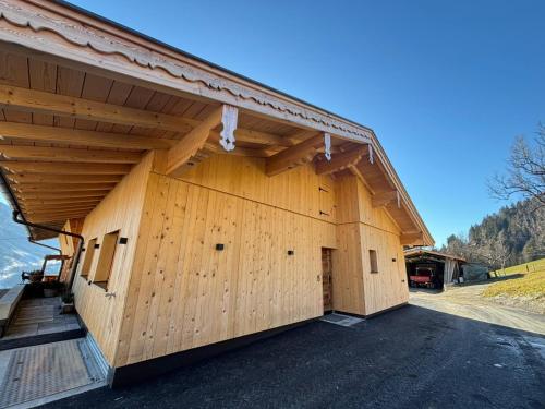 a large wooden building with a large garage at Apartment Bichlhof in Brixen im Thale