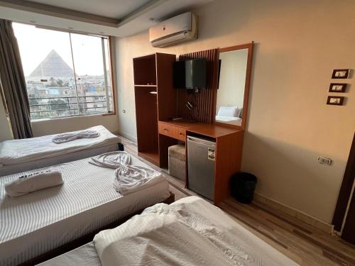 En eller flere senge i et værelse på First pyramids view inn