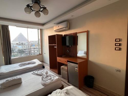 En eller flere senge i et værelse på First pyramids view inn