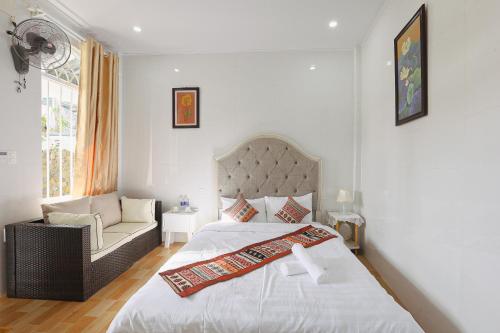 a bedroom with a bed and a chair and a window at Huế Silk Homestay in Cồn Giả Viên