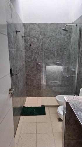 a bathroom with a shower with a toilet and a sink at Bosquesito in Mina Clavero