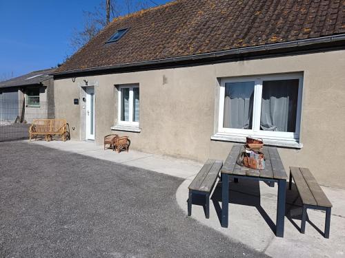 een tafel en bank voor een huis bij Maison Le Platier d'Oye in Oye-Plage
