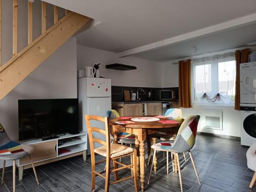 een keuken en eetkamer met een tafel en stoelen bij Maison Le Platier d'Oye in Oye-Plage