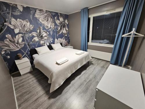 een slaapkamer met een bed met een bloemenbehang bij Lappi in Tornio