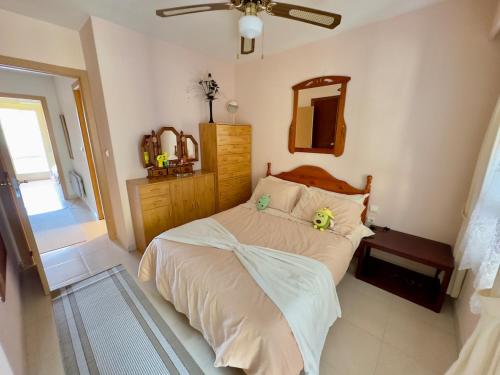 Schlafzimmer mit einem Bett, einem Deckenventilator und einem Spiegel in der Unterkunft Casa Sol y Paz in El Campello