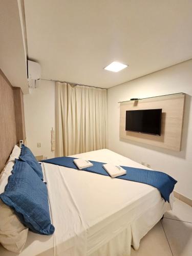 a bedroom with a large bed with a tv on the wall at Landscape Beira Mar in Fortaleza