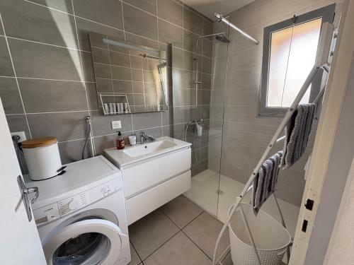 a bathroom with a washing machine and a sink at Albizias 3 in Eugénie-les-Bains