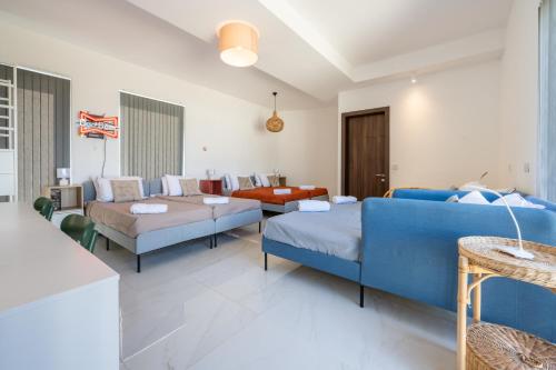 un soggiorno con un divano e sedie blu di Design Luxury Penthouse with Private Pool a Żurrieq