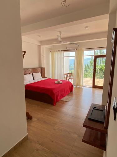 a bedroom with a red bed and a large window at Hotel H2O in Gampola