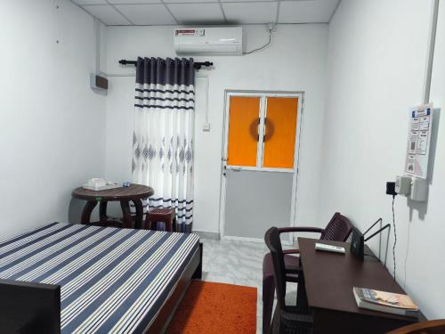 een kamer met een bed, een bureau en een raam bij TN Travel Inn - Katunayake in Katunayaka