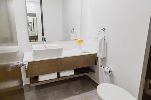 a white bathroom with a sink and a mirror at GHL Style Barrancabermeja in Barrancabermeja