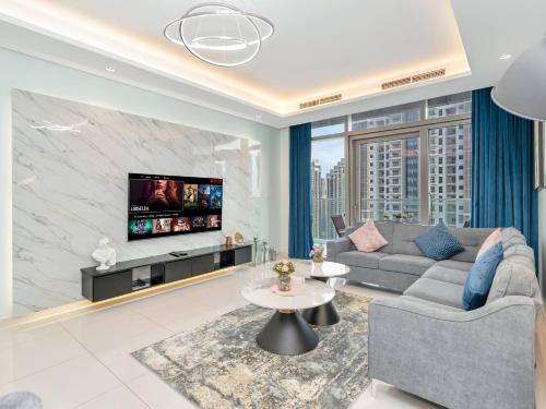 a living room with a couch and a tv at Burj Khalifa Downtown Views - Highest Infinity Pool in Downtown in Dubai