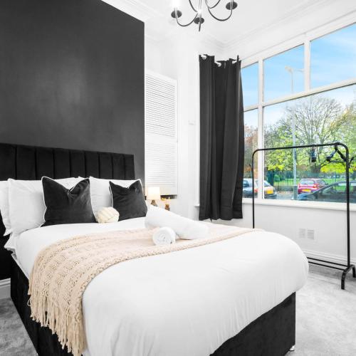 a bedroom with a large bed with a large window at Spacious Apartment - Parking - Smart TV - Netflix 9PC in Wolverhampton
