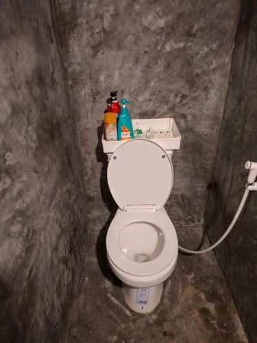 een badkamer met een wit toilet in een kamer bij Phayam Hostel in Ko Phayam