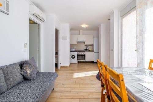 een woonkamer en keuken met een tafel en een bank bij Inftour President 2 Apartamento in Calpe