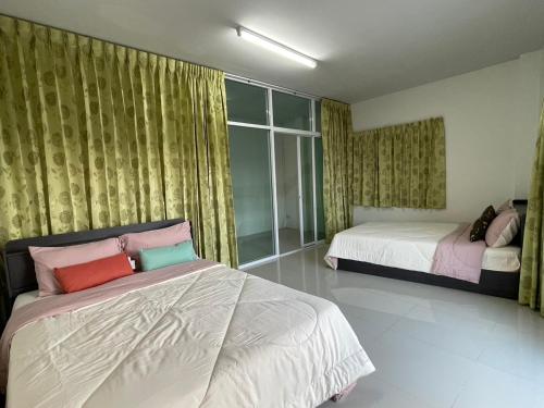 une chambre avec deux lits et une fenêtre dans l'établissement ท่าบูรพาวิลล่า ที่พักพร้อมสระน้ำ ทั้งหลัง, à Ban Hua Khao Sammuk