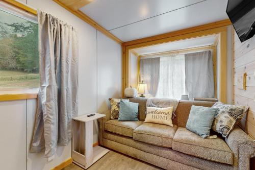 een woonkamer met een bank en een raam bij Charming Tiny Home Studio Sleeps 2 - Grill - Porch in Acuff